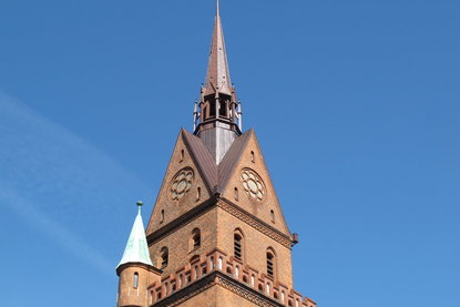 Propst Christoph Giering - Copyright: Ev.-Luth. Kirchenkreis Lübeck-Lauenburg Die Turmspitze der Herz-Jesu-Kirche ragt in den blauen Himmel - Copyright: Ev.-Luth. Kirchenkreis Lübeck-Lauenburg